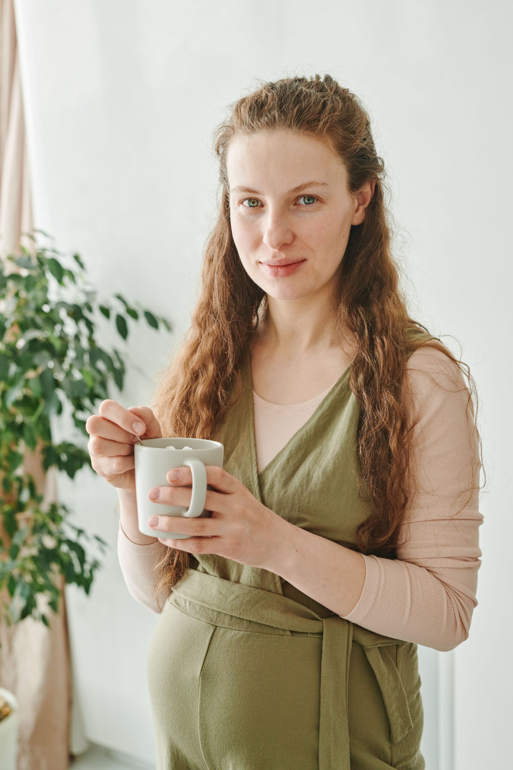 coffee during pregnancy: pregnant woman holding a cup of coffee Title: Pregnant Woman Holding a Cup of Coffee